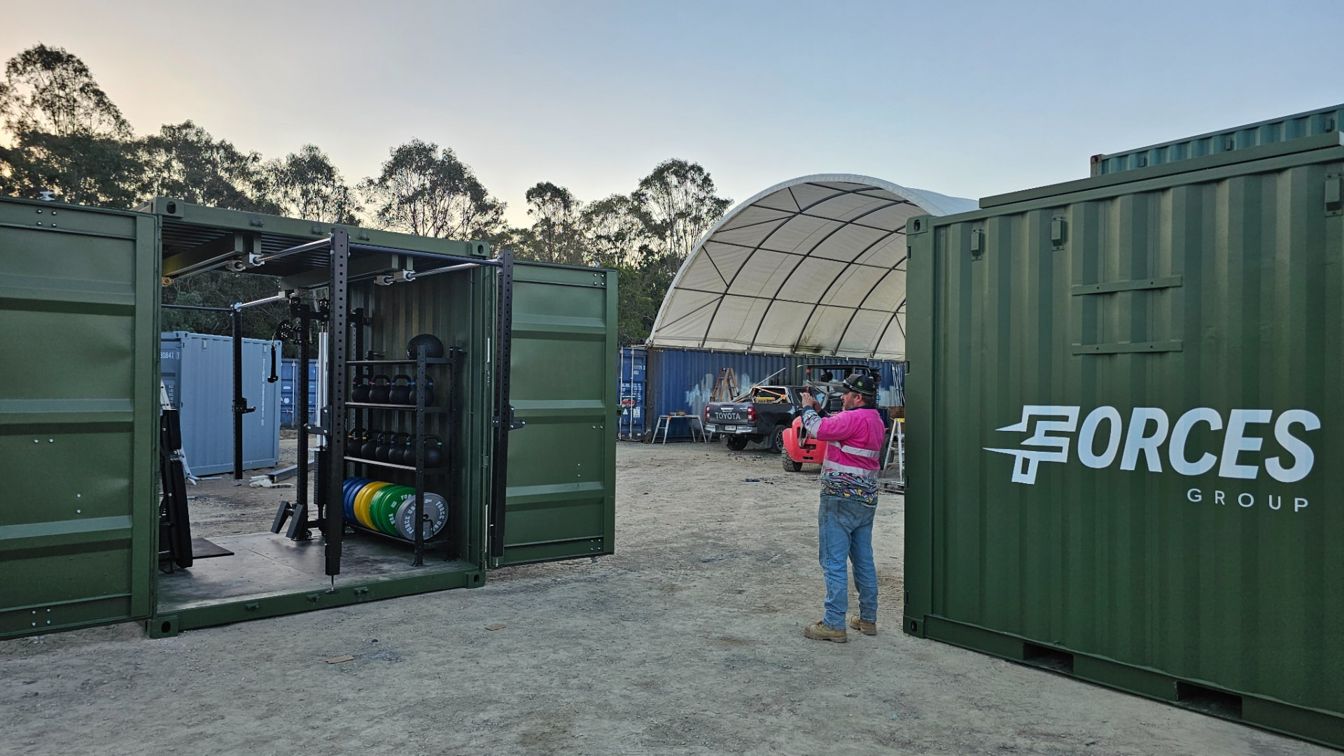 Open FORCES Rapid human-performance system beside a branded container in the production yard